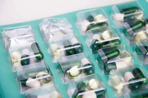Multi-dose medication packaging with pills organized into individual compartments